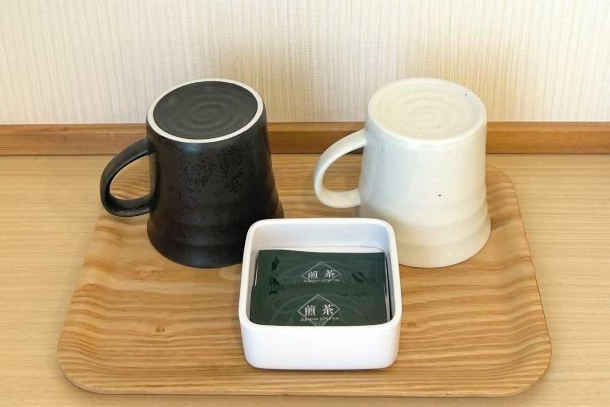 Two ceramic mugs on a wooden tray.