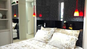 Relax in a stylish bedroom with a large bed, wardrobe, and pendant lights.