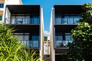 Un edificio moderno con fachada simétrica, ventanas grandes y balcones.