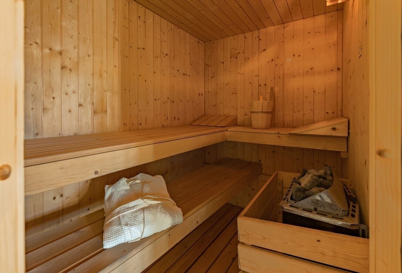 Een sauna met houten banken en een klein plankje.