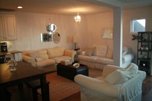 A living room with a sofa set, a coffee table, and a bookshelf. - Ocean and Beach View Townhouse at Mandalay Beach in Oxnard, California (Oxnard)