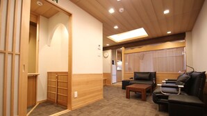 A room with a wooden floor, a sofa, a coffee table, and a sliding door. - Kyoto Guest House Gion (Kyoto)