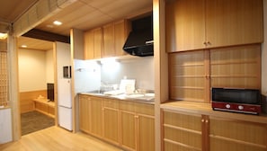 Compact kitchen with microwave, range hood, and seating area.