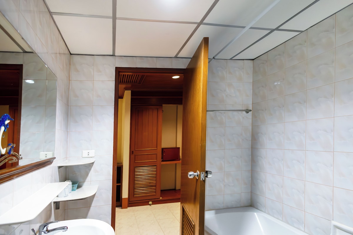 A bathroom with a sink, mirror, and bathtub.