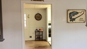 A hallway with a 'Relax' sign, a rustic wall clock, and a 'Gone fishing' sign. - Cozy cottage on the lake (Liberty Hill)
