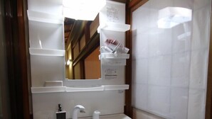 A bathroom with a white sink, mirror, and shelves above the sink. - Private Residence Kyoto Kiyomizu (Kyoto)