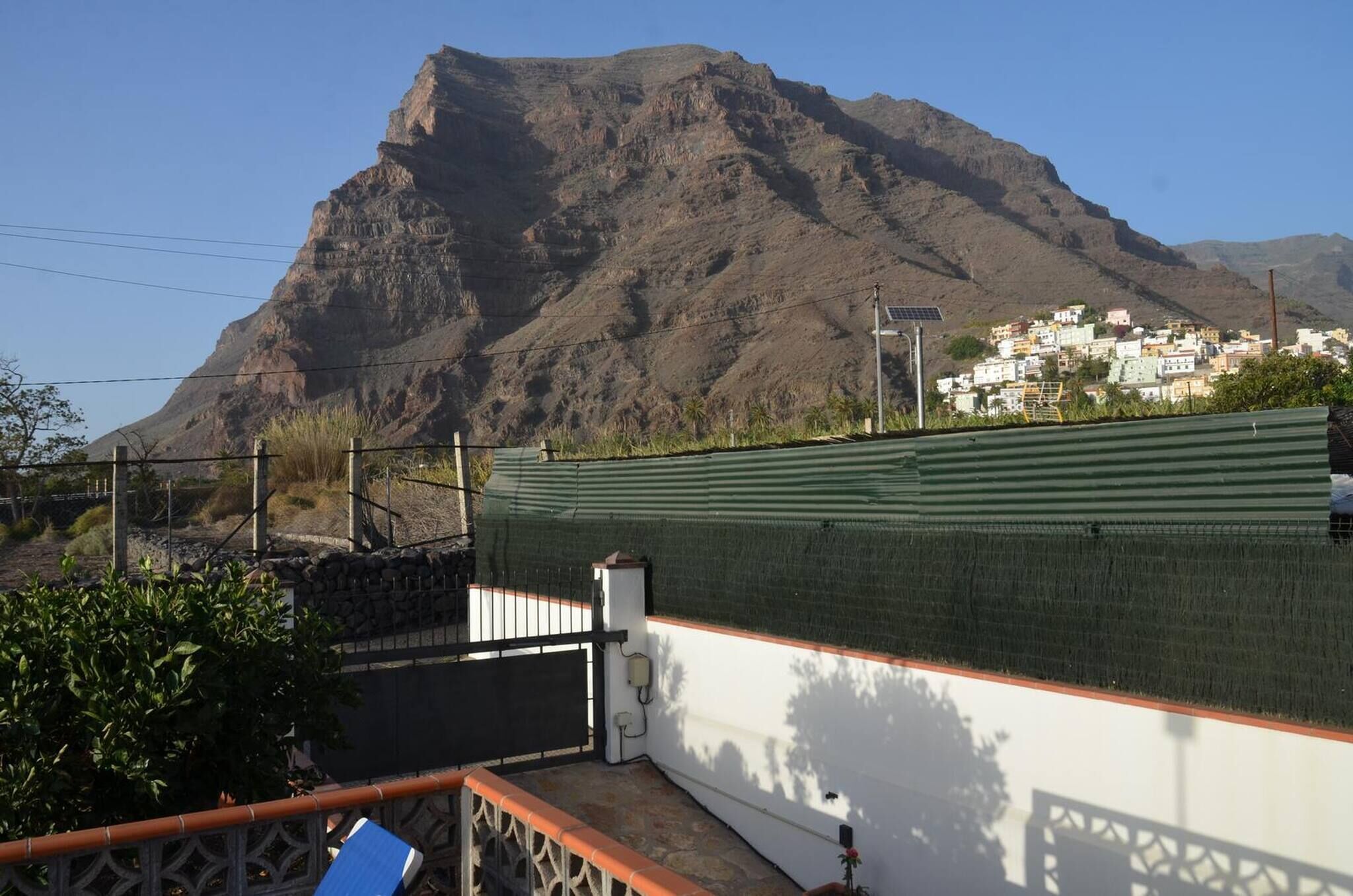 A mountain with a residential area in the background.