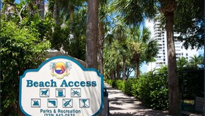 A sign for Beach Access with icons indicating facilities like trash, bicycle, and glass recycling. - 5th Fl condo, steps to JW Marriott & Beach, Sunset Views, walk to restaurants (Marco Island)