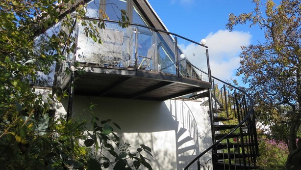 A house with a glass balcony, surrounded by trees and a clear sky. - RügenHeart 3 Dachträume - RügenHeart 3 Dachträume (Parchtitz)