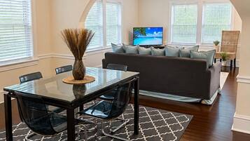 A living room with a sofa, TV, and ceiling fans.