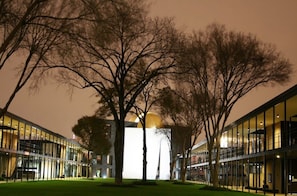 Un edificio moderno con fachada de vidrio y una estructura central iluminada.