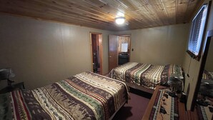 A room with two beds, wooden ceiling, and a door leading to another room. - Eagle Nest Fly Shack and Lodge (Eagle Nest)