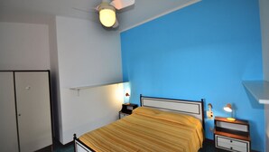 Ein Schlafzimmer mit einem Bett, Nachttischlampen, einem Deckenventilator und einem Kleiderschrank.