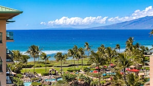 A resort with a pool, palm trees, and a view of the ocean. - Maui Resort Rentals: Honua Kai Hokulani 736 – 7th Floor Ocean & Mountain Views w/ King Size Balcony! (Lahaina)