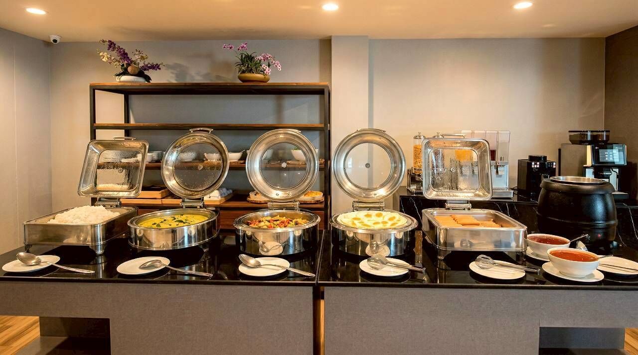 A buffet setup with various food items and a coffee machine.