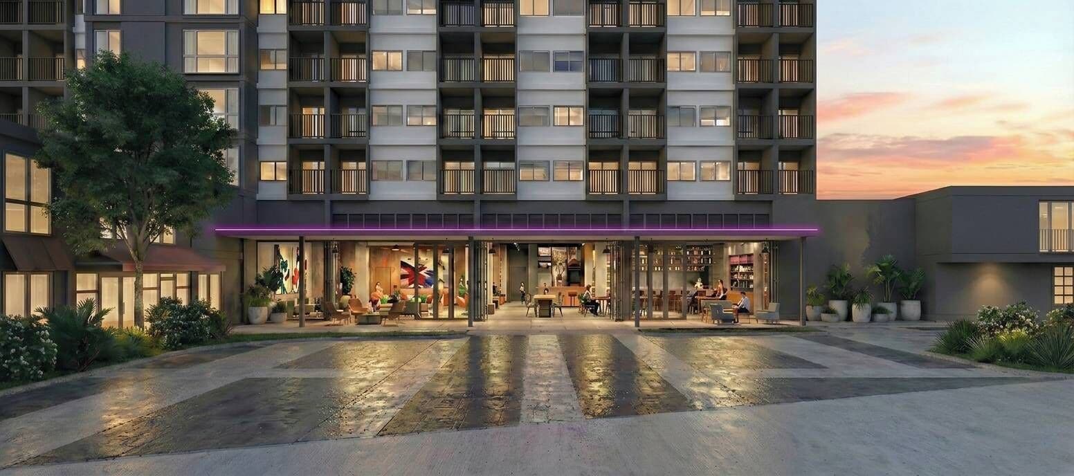 A modern hotel with a ground-level restaurant and outdoor seating.