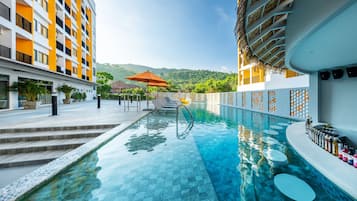 Una piscina al aire libre, sillones reclinables de piscina