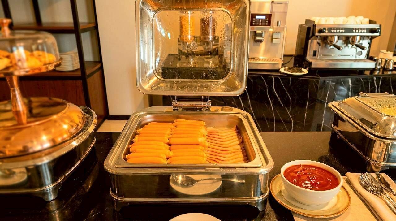 Un buffet proposant divers plats, notamment un récipient rempli de tranches d’orange et un bol de sauce rouge.