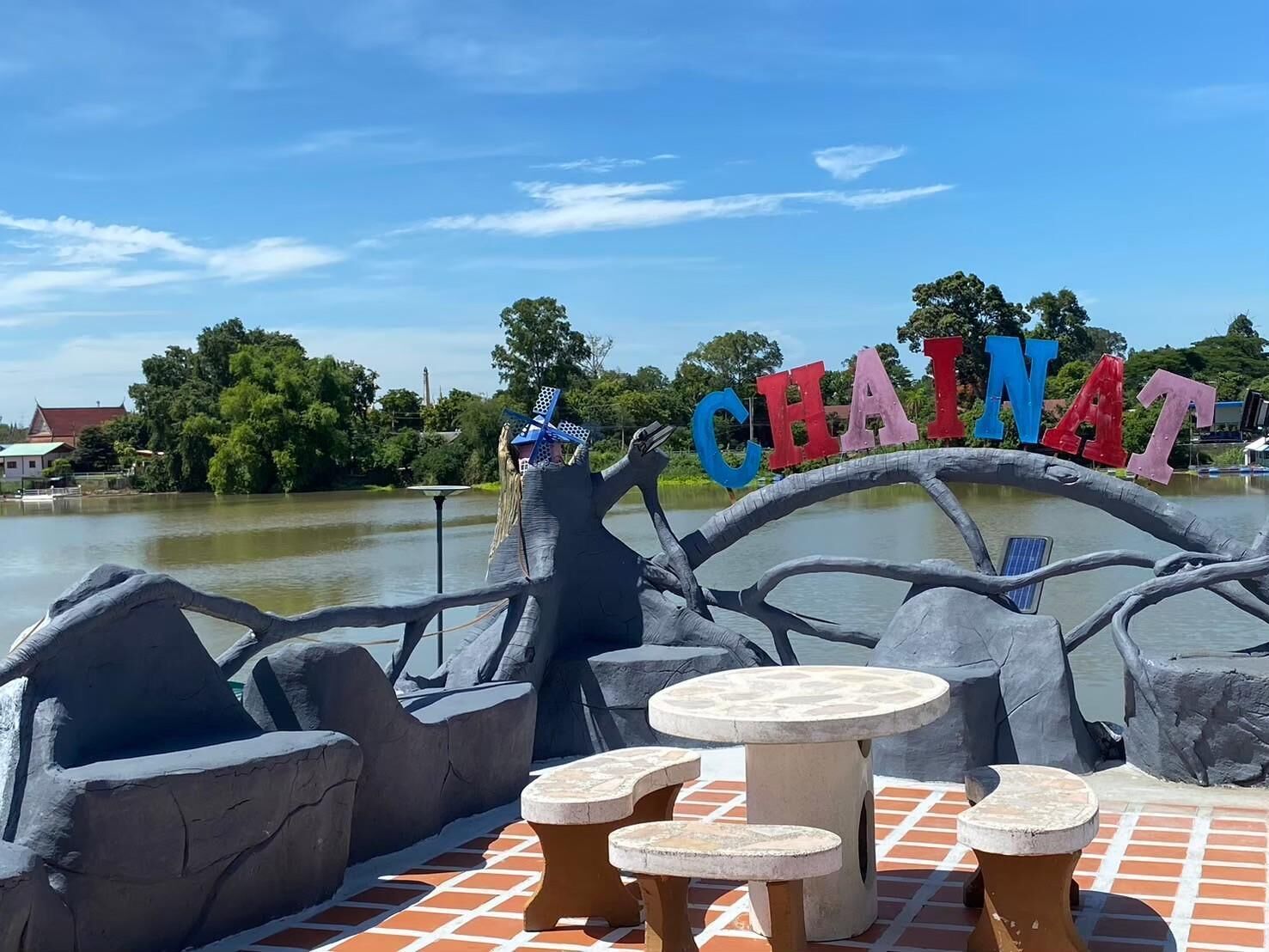 A sign reading 'CHAINAT' with a boat-shaped structure and seating area.