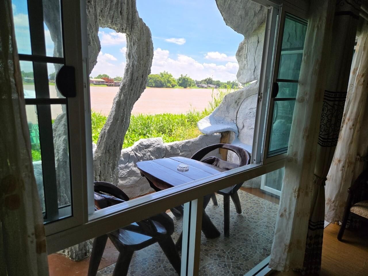 Una habitación con vista al río, una mesa y sillas.