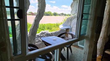 Una habitación con vista al río, una mesa y sillas.