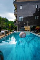 Una piscina al aire libre, camas de piscina gratis, sombrillas