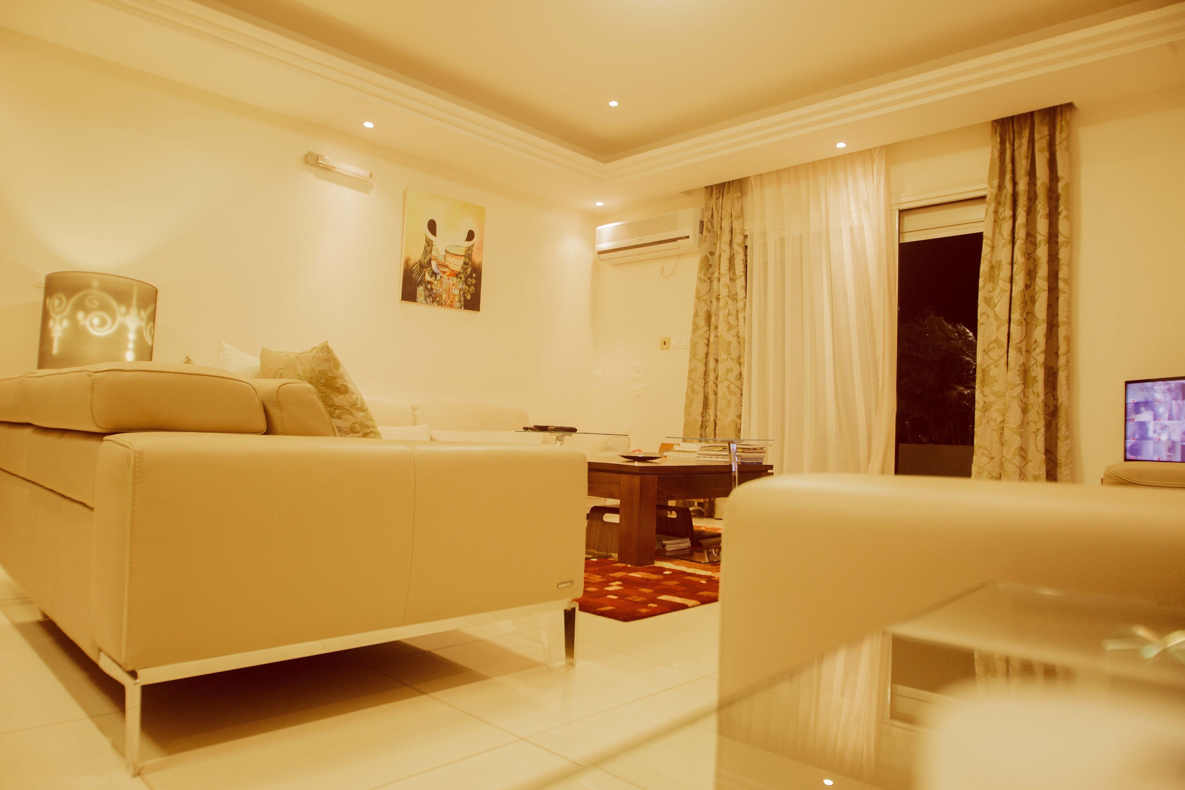 A living room with a sofa, a coffee table, and a TV.