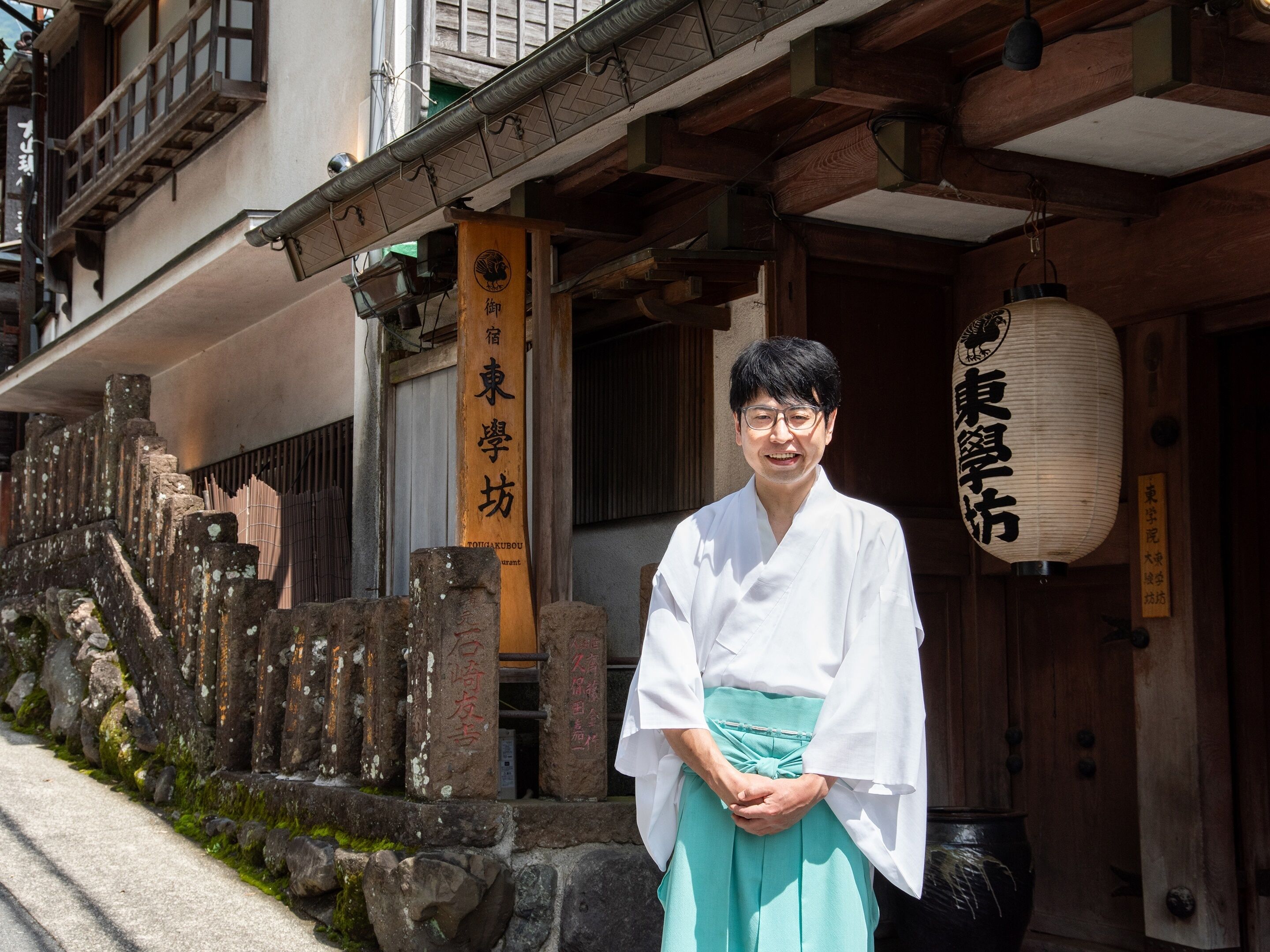 Ein traditionelles japanisches Gebäude mit Holzbalken und einer Steinwand.
