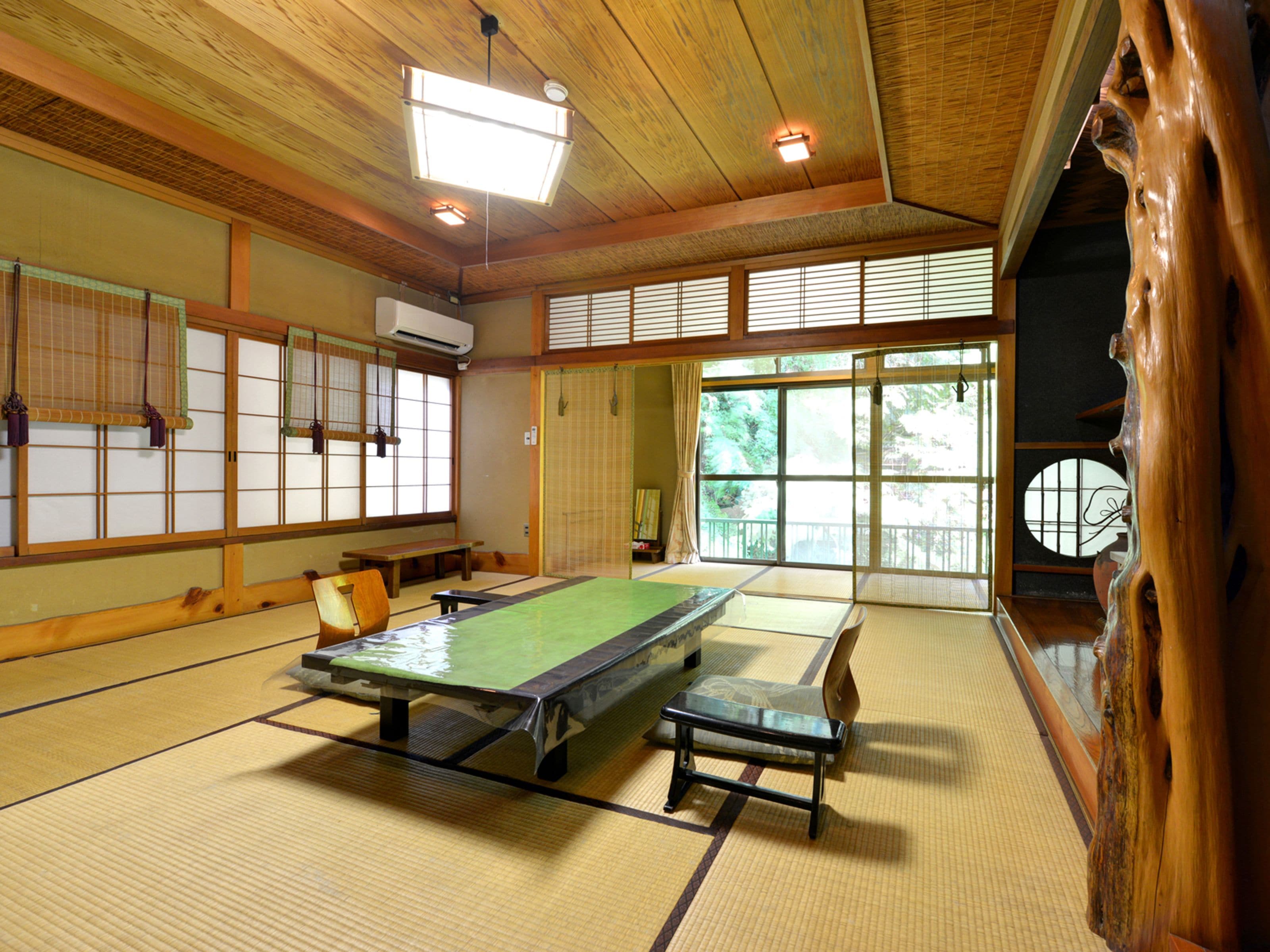 Ein Raum mit Tatami-Matten, einem Tatami-Tisch, Bänken und verschiebbaren Türen.