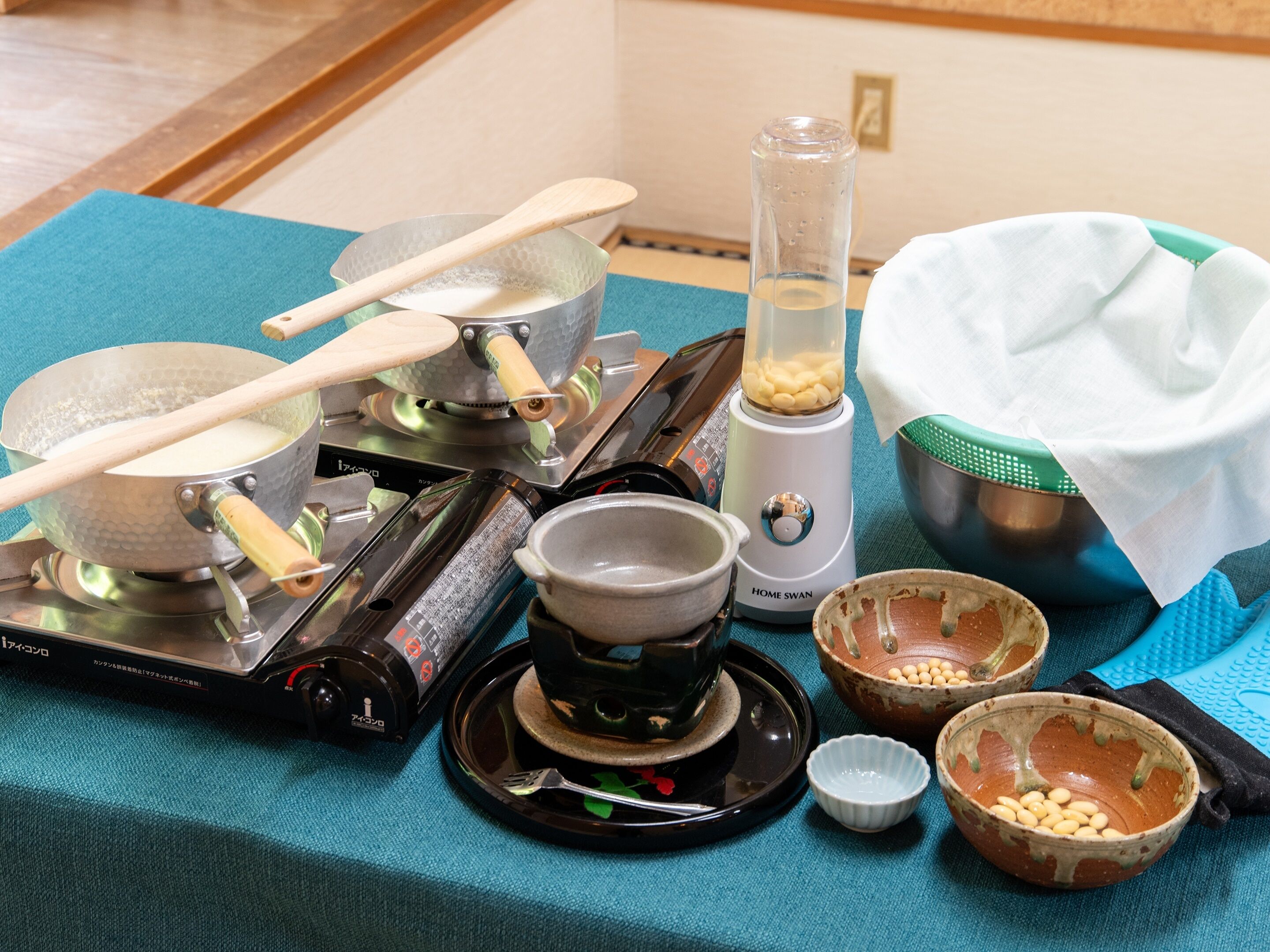 A kitchen setup with a stove, pots, a blender, and bowls containing beans.