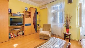 A living room with a TV, wooden furniture, a chair, and a bookshelf. - 1 bedroom awesome apartment in Bakar (Bakar)