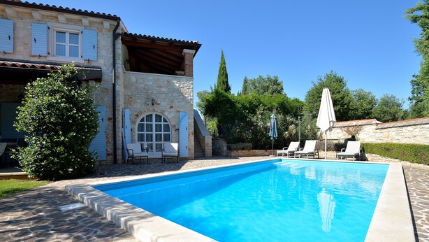 A swimming pool with stone tiles, a stone building with blue shutters, and a clear blue sky. - Lovely Stone House with Own Pool in Quiet Village (Tar)