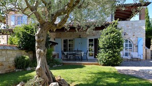 A stone house with a patio, a dining area, and a large tree in the foreground. - Lovely Stone House with Own Pool in Quiet Village (Tar)