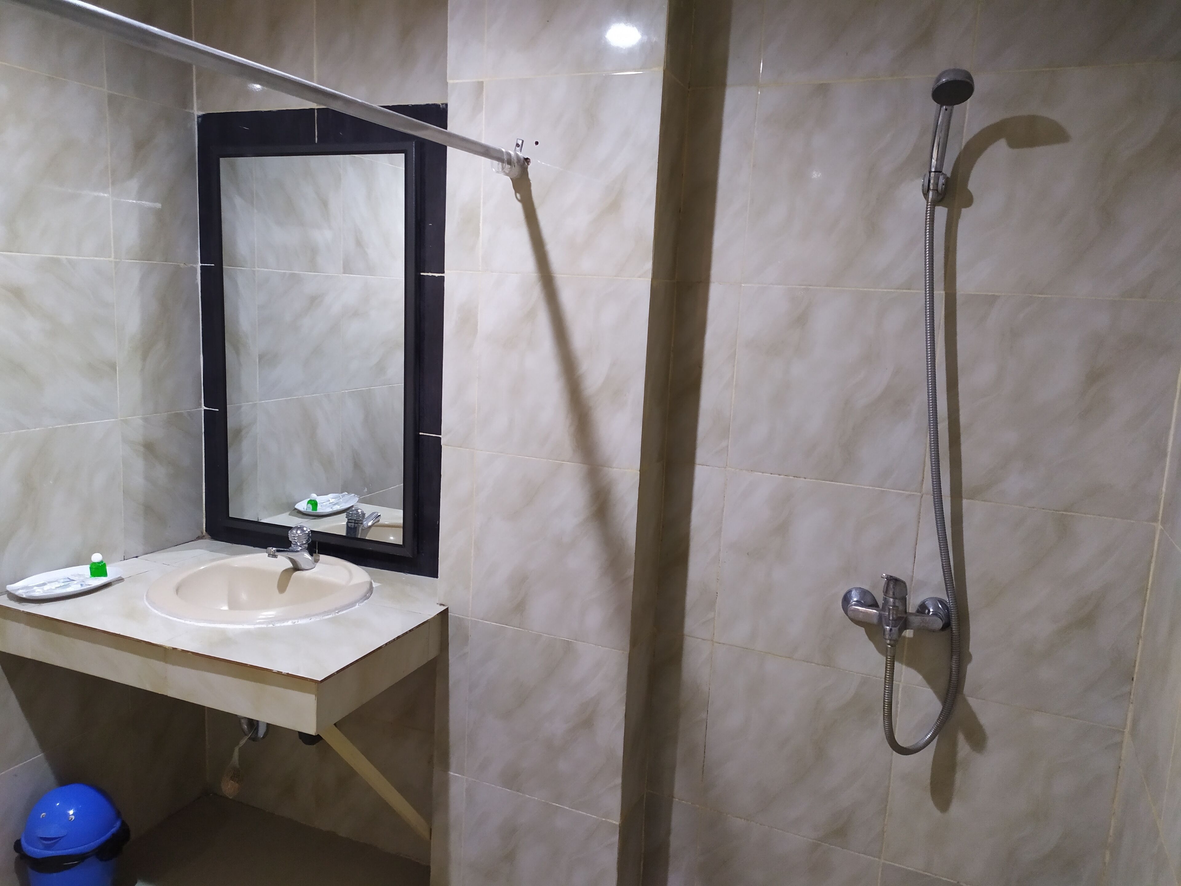 A bathroom with a sink, mirror, and shower.