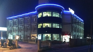 A multi-story hotel with a curved facade, large windows, and blue exterior lighting. - Hotel Rangkayo Basa Padang Panjang (Padang Panjang)