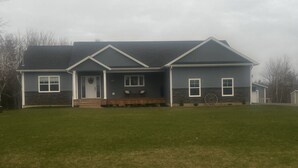A two-story house with a front porch, a garage, and a well-maintained lawn. - Your Home Away From Home- 4 bed, 3 bath, centrally located. (Mermaid)
