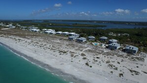 An aerial view of a coastal resort with beachfront villas, a swimming pool, and a view of the ocean and nearby water bodies. - Very Nice and Comfortable with a Great View of the Gulf on the Resort, A3724A (Cape Haze)