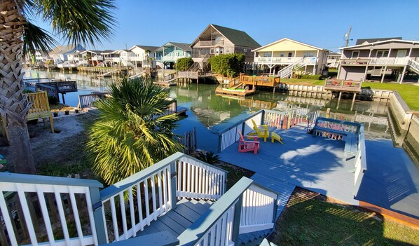 A waterfront property with multiple houses, docks, and a small dock area with chairs and a table.