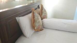 A bed with white linens and two decorative pillows. - Kunigen Villa Kuta Bali (Kerobokan)