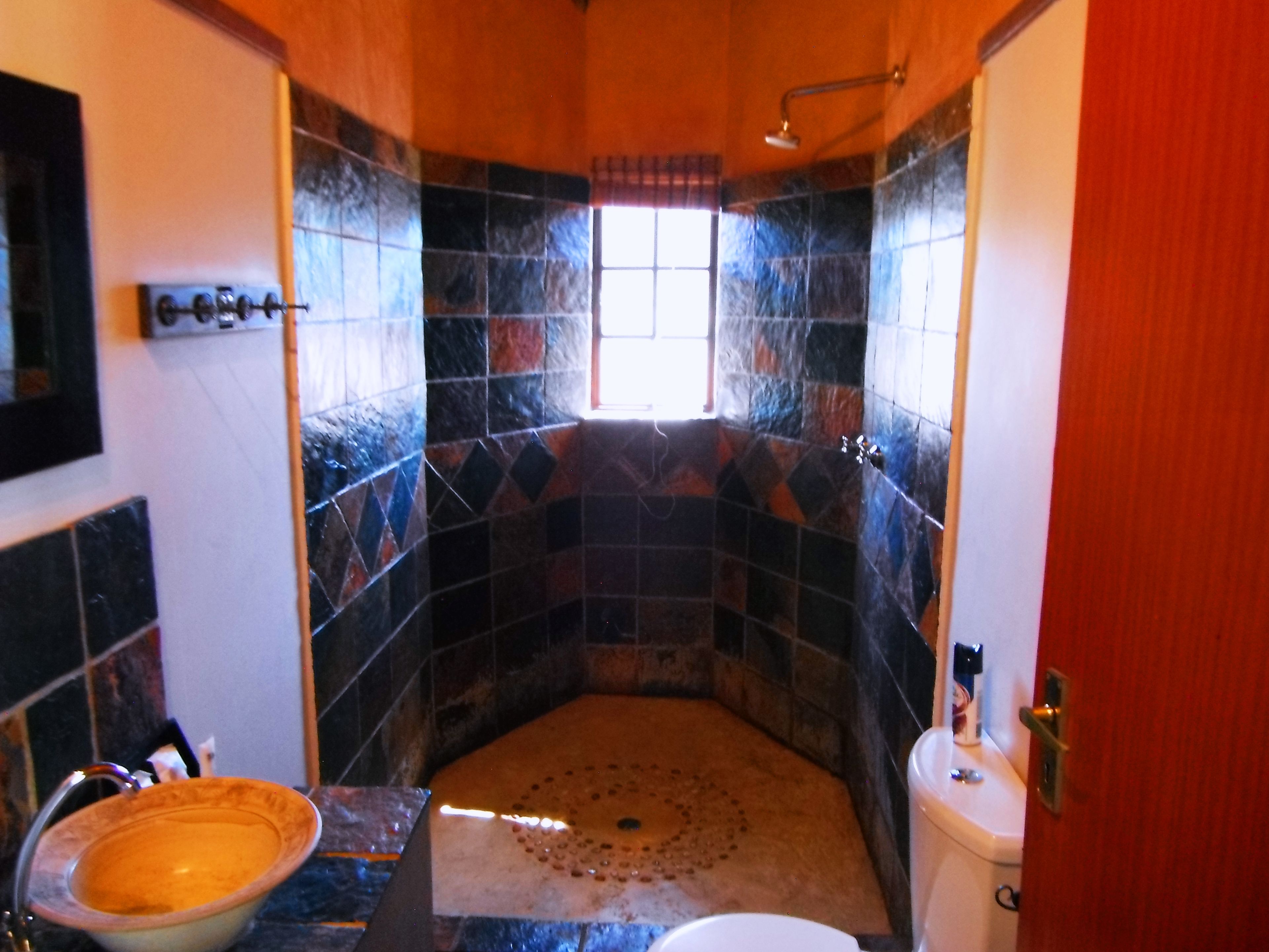 A bathroom with a shower, a sink, and a toilet.