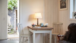 A dining area with a table, chairs, a lamp, and a bowl of fruit. - Villa Weidling B&B (Fengersfors)