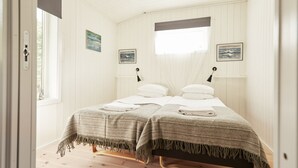 A room with two beds, wooden flooring, white walls, and a window with a view. - Villa Weidling B&B (Fengersfors)