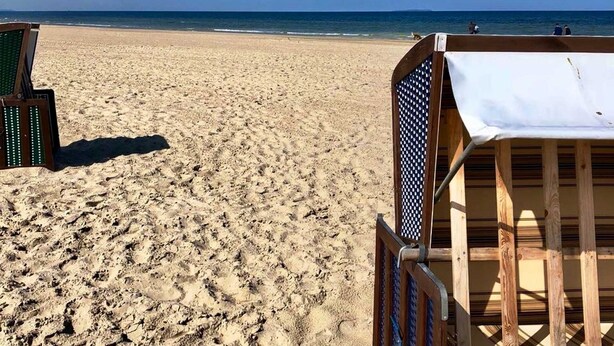 A beach with a wooden beach chair and a metal chair with a checkered pattern. - Tobias house rental - Tobias house (Karlshagen)