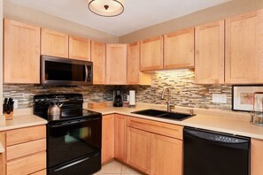 Enjoy cooking in this well-equipped kitchen with a stainless steel stove, microwave, and dishwasher.