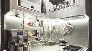 A compact kitchen with a coffee machine, sink, and stove. - Suite Sweet Rome (Rome)