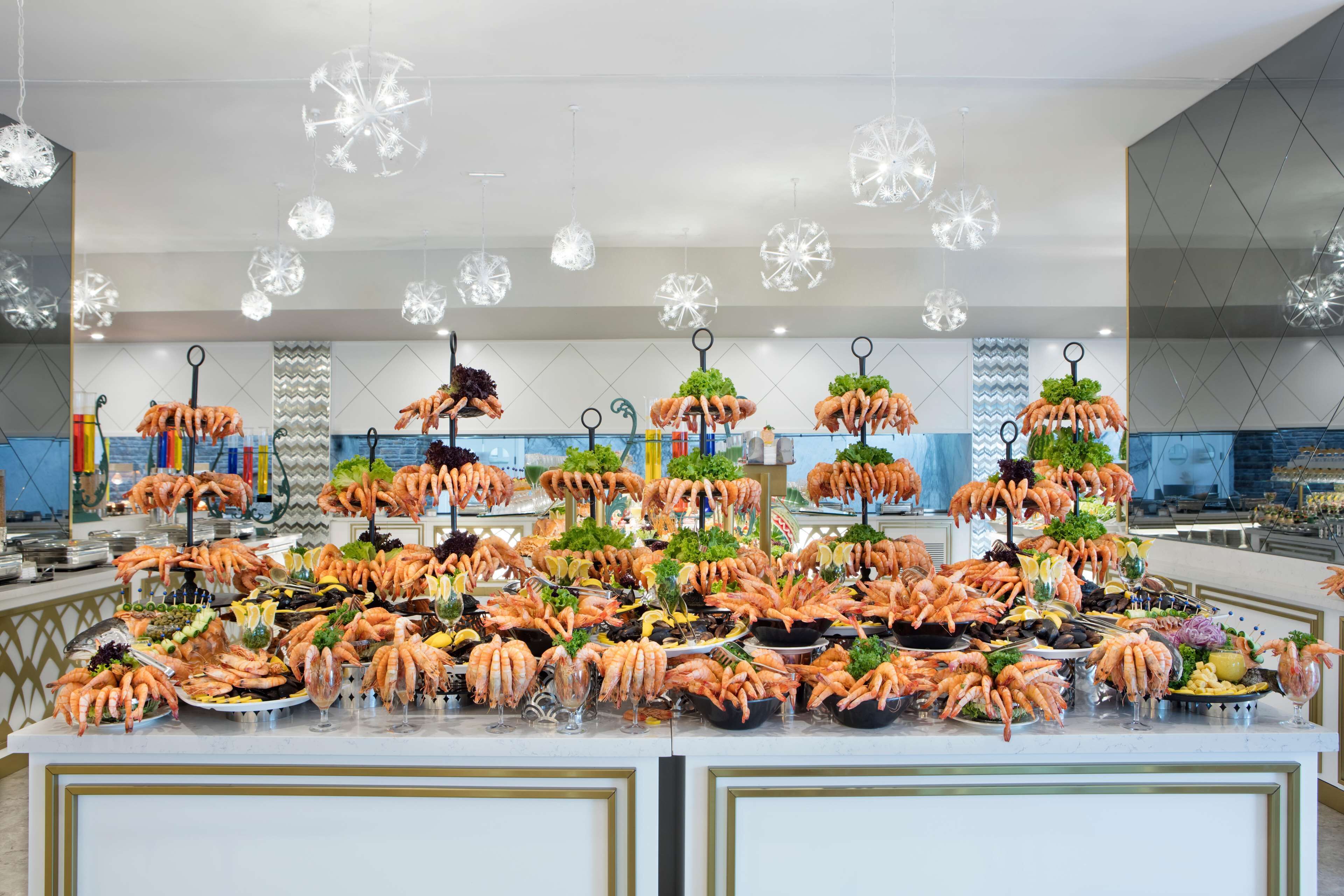 A buffet with various seafood items, including shrimp, arranged on a counter.