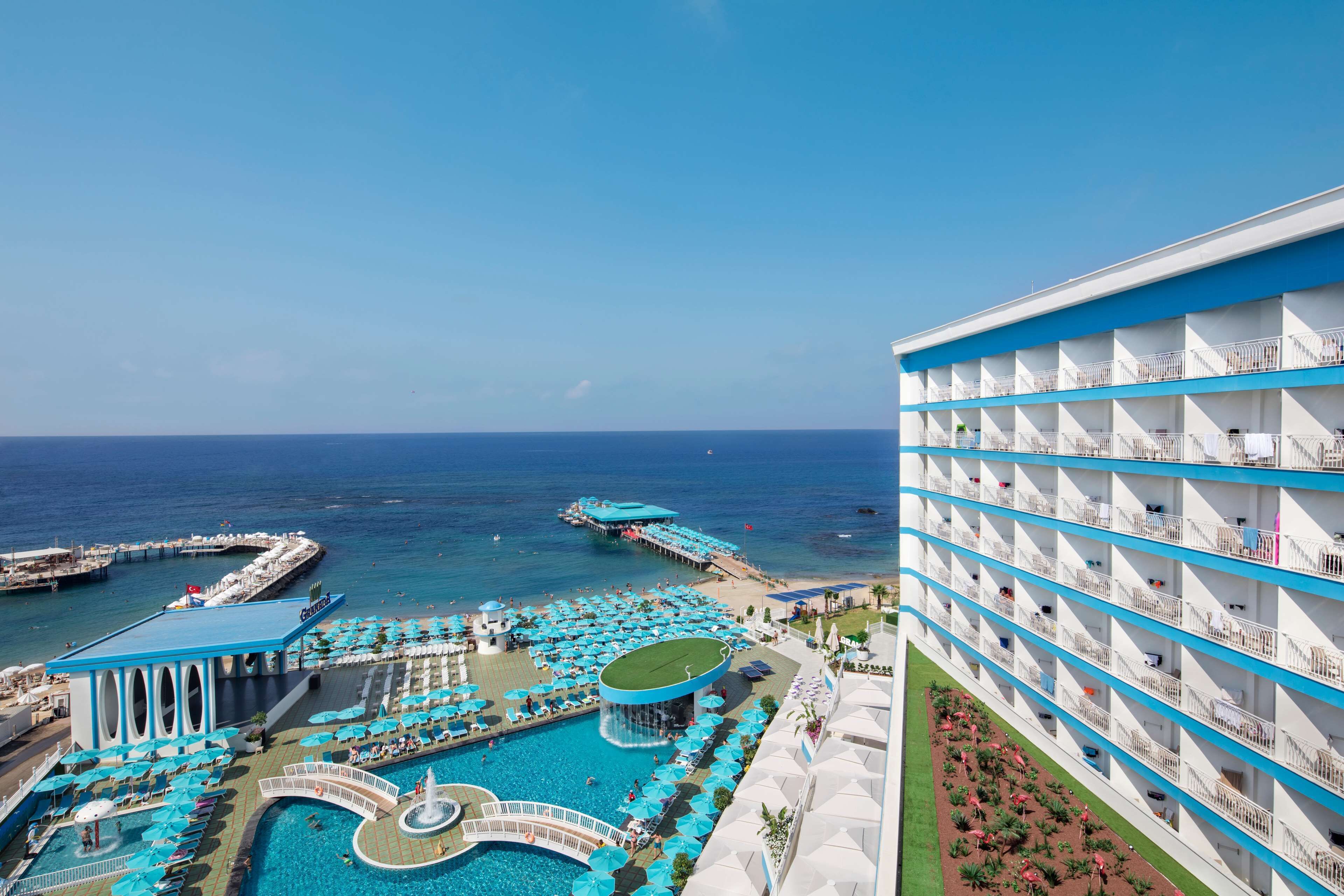 A hotel with a pool area, multiple balconies, and a view of the ocean.