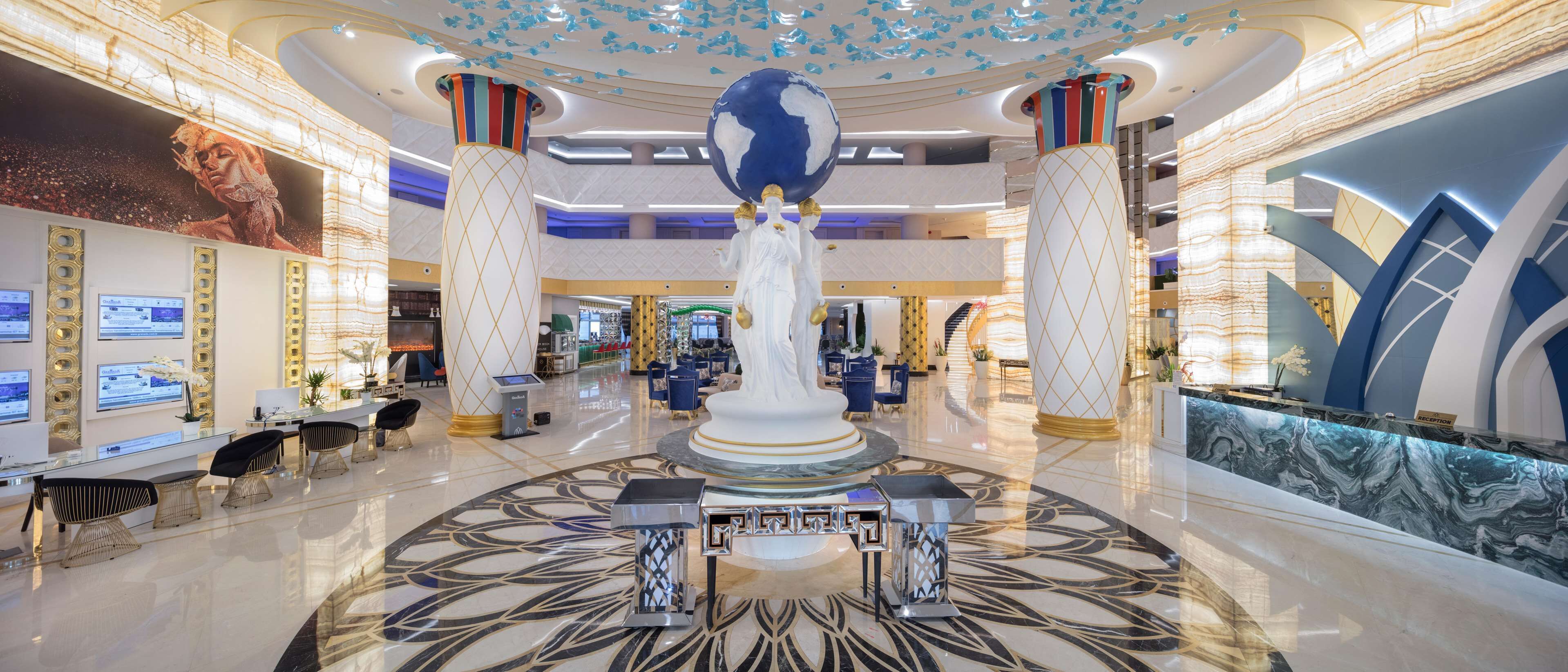 A spacious lobby with a central globe sculpture, high ceilings, and modern decor.