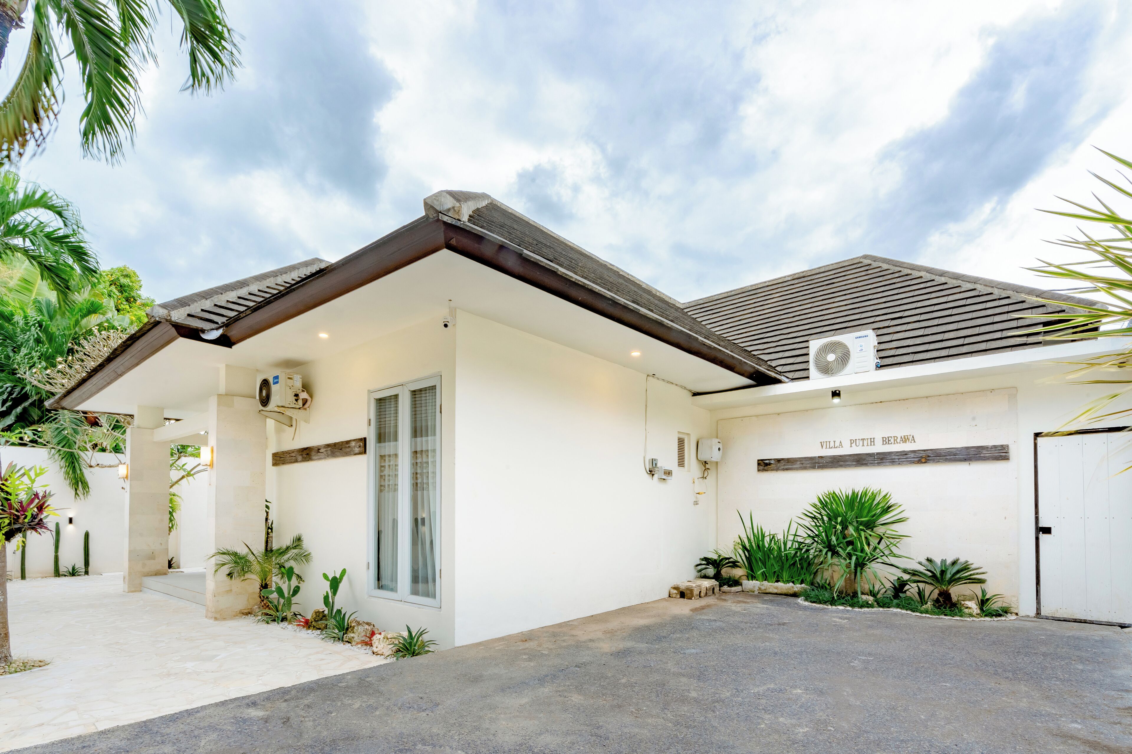 Une villa dotée d’un porche, d’un garage et d’une enseigne indiquant « Villa Putih Berawa ».