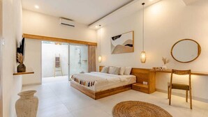 Un dormitorio moderno con una cama grande, una mesita de noche de madera, un espejo redondo y una alfombra tejida.